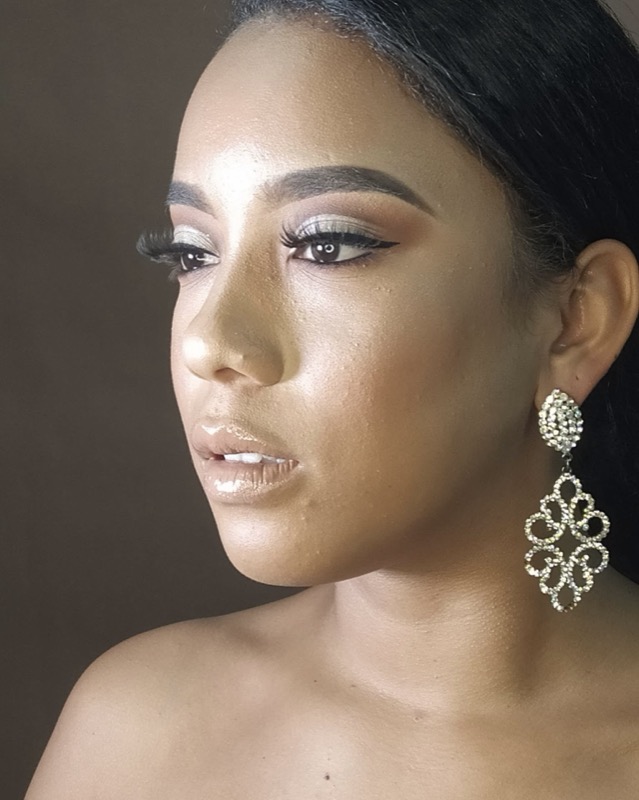 Maquillaje social elegante con piel luminosa, sombras nude y delineado cat eye en modelo con aretes brillantes